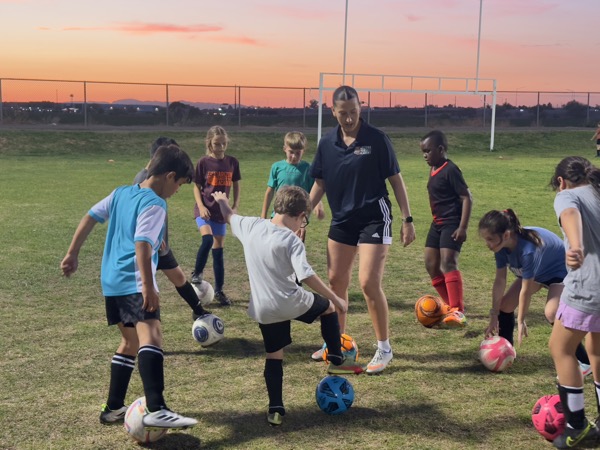 Players moving with the ball around a coach outdoors