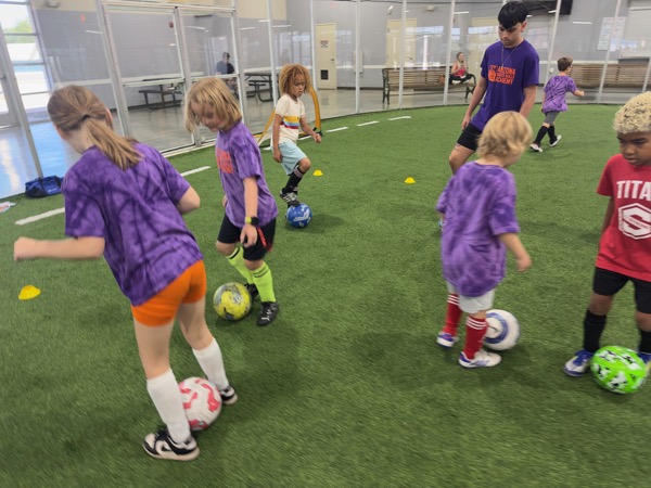 Young players dribbling indoors