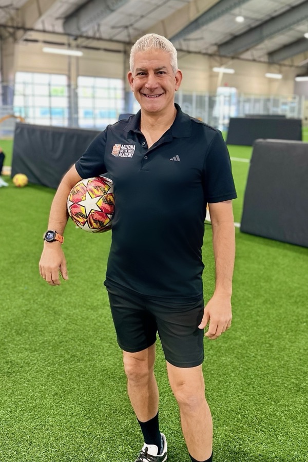 Coach Rizzo holding a ball on the indoor turf